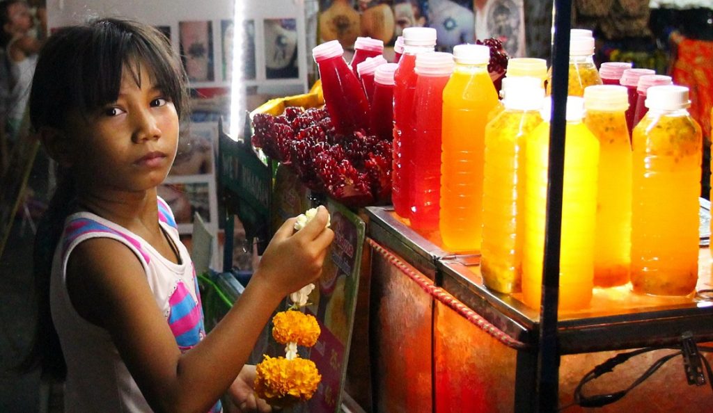 バンコクのカオサン通りで花を売って一生懸命に生きている少女の写真