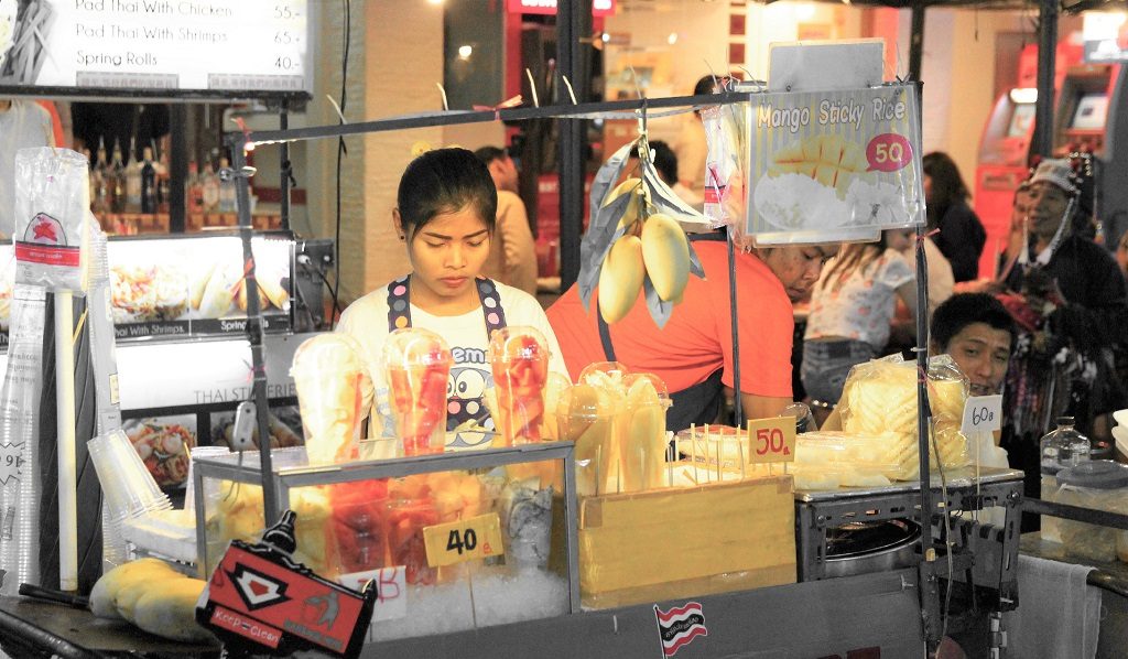 タイのバンコクのカオサン通りで果物を売る女性の写真
