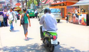 タイ旅行バンコク市内を走るバイクと女性　バックは歩道側に
