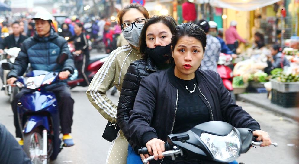 ハノイ旧市街をバイクで三人乗りで走る女性｜ベトナム旅行