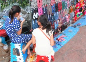 バンコクのチャトゥチャックマーケット前の露店で働く少女たち