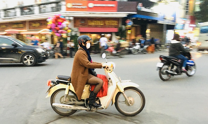ベトナムの空港からハノイ観光へ移る｜バイクで走る女性