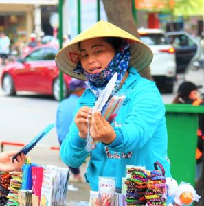 ベトナムの観光地で歩いて行商をするベトナム人の女性
