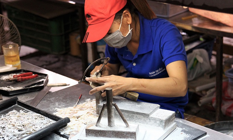 ホーチミンの螺鈿細工の工場で糸ノコギリで貝を加工する職人の写真｜ベトナム旅行
