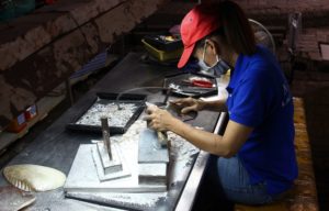 ホーチミンの伝統工芸品｜螺鈿細工の工場で小刀で貝を切る職人の写真｜ベトナム旅行