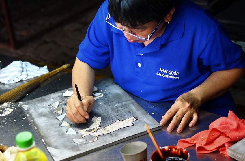 ホーチミン螺鈿細工の工場で型に合わせて木材を加工する職人の写真｜ベトナム旅行