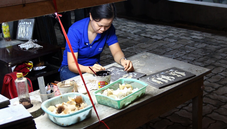 ホーチミンの螺鈿細工の工場でくり抜いた木に貝を埋め込んでいく職人の写真｜ベトナム旅行