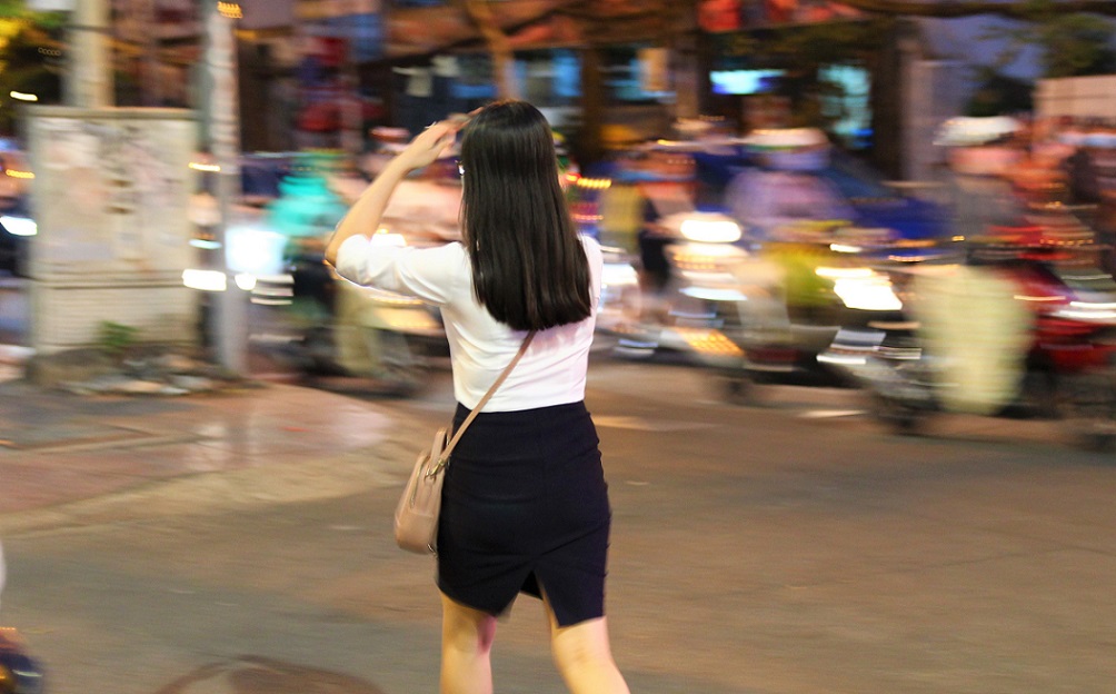 ベトナムの日本人向け定番夜遊びスポットが集中するホーチミンを歩く若い女性OLの写真