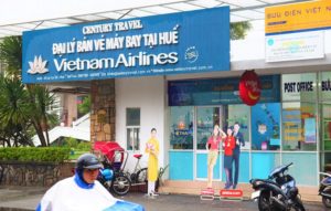 フエのフーン川横の郵便局とベトナム航空の代理店の写真