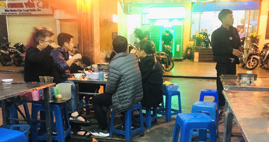 ハノイ旧市街のドンスアン市場のフードコートで食事する現地の人々の写真