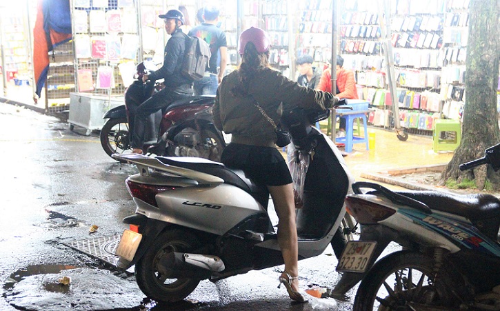 ハノイ旧市街の定番お買い物スポットのドンスアン市場で買い物を終えてバイクで買える女性の写真｜ベトナム旅行