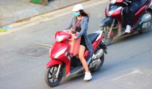 ハノイの大通りをバイクで走る女性｜ベトナム