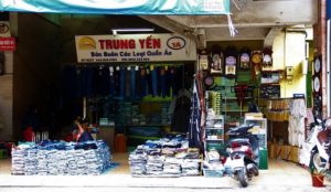 ハノイ最大のドンスアン市場でジーンズを売る服屋の写真