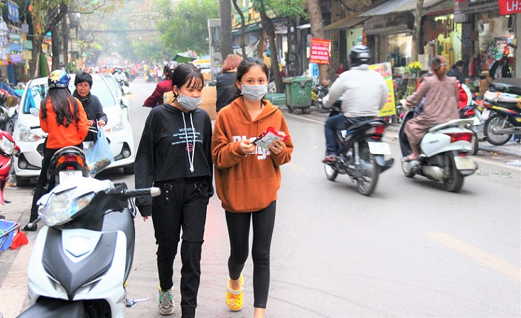 ハノイのハンチエウ通りとグエンシエウ通りの交差点を歩くベトナムの少女達の写真