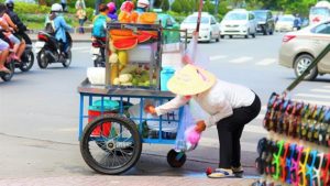 ホーチミンのフォークインの前で果物を売るベトナム人女性の写真