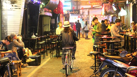 ハノイの夜の街で仕事を終えて帰るベトナムの女性の写真
