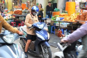 ハノイ旧市街のドンスアン市場で夕食のおかずを買う若いベトナム人女性の写真