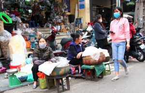 ハノイ旧市街のドンスアン市場横のハンコアイ通りを通るベトナム人女性の写真