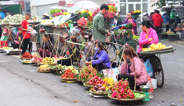 ハノイ旧市街のドンスアン市場裏のグエンティエントゥアット通りで野菜を売る人々の写真