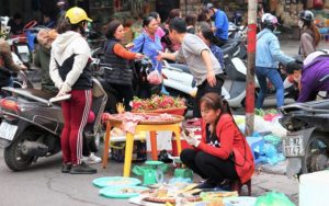 ドンスアン市場の場外でドラゴンフルーツなどの果物を売っている家族の写真
