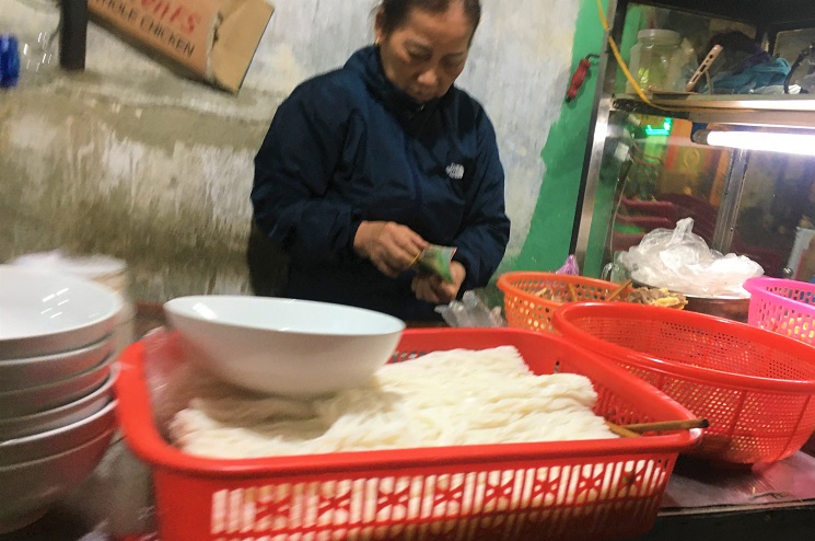 会計を担当している安食堂のおばちゃんがベトナム料理の仕込みをしている写真