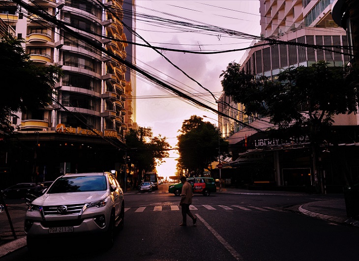 早朝のニャチャンのグエンティミンカイ通りを歩く男性の写真