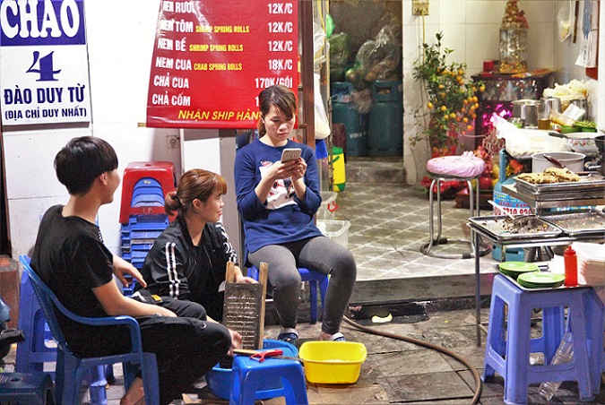 ルオンゴッククエン通りのベトナム料理のＢ級グルメ食堂で客引きする女性の写真