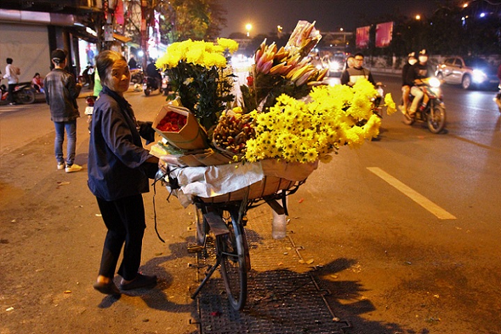 ハノイ旧市街のチャンニャットズアット通りで自転車で花を売る行商のベトナム人女性