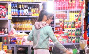 ハノイの近所の古い商店に買い物に来たベトナム人の小学生の少女