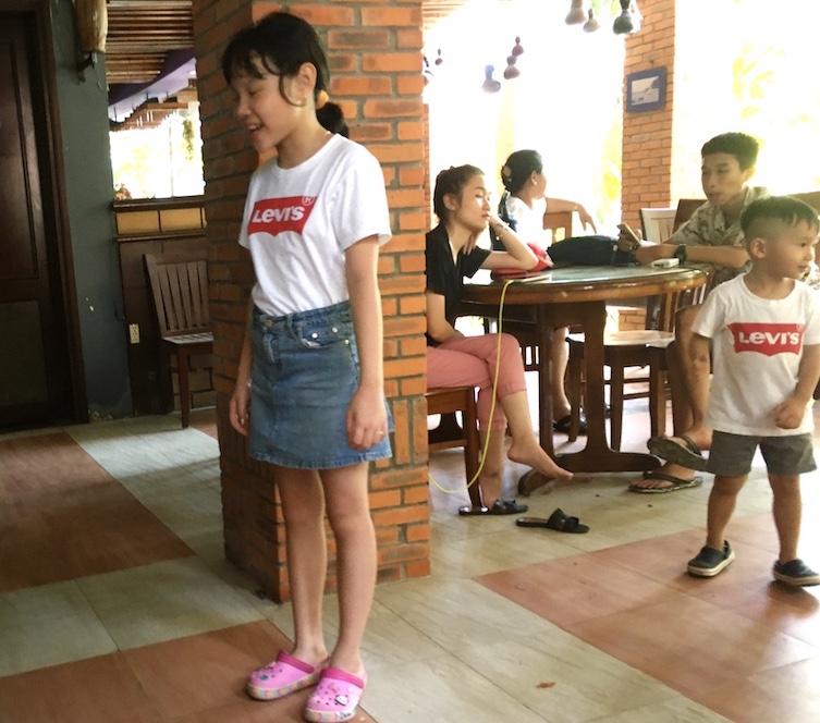 ファンティエットのHoang Ngoc Resortホテルのロビーで遊ぶリーバイスのTシャツを着たベトナムの女の子の写真